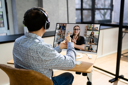 Person using sign language to attend an online conference with other sign language speakers using his laptop