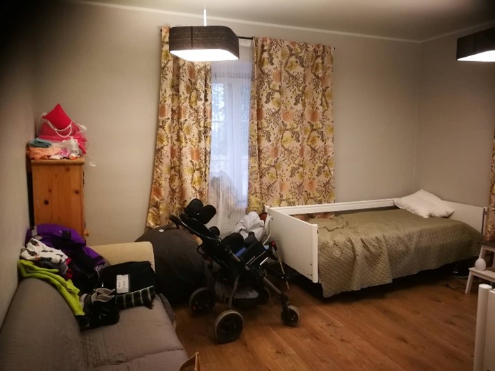 a bedroom with a bed and a stroller