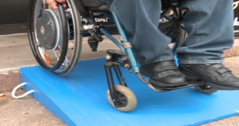 a person sitting in a wheelchair with their feet on top of a blue mat