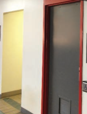 a red and black door and a persons with disabilities sign on the wall next to it in the middle of an empty hallway